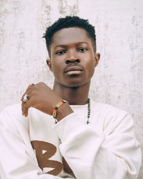 Portrait of a young man with afro hairstyle and casual attire, exuding confidence.