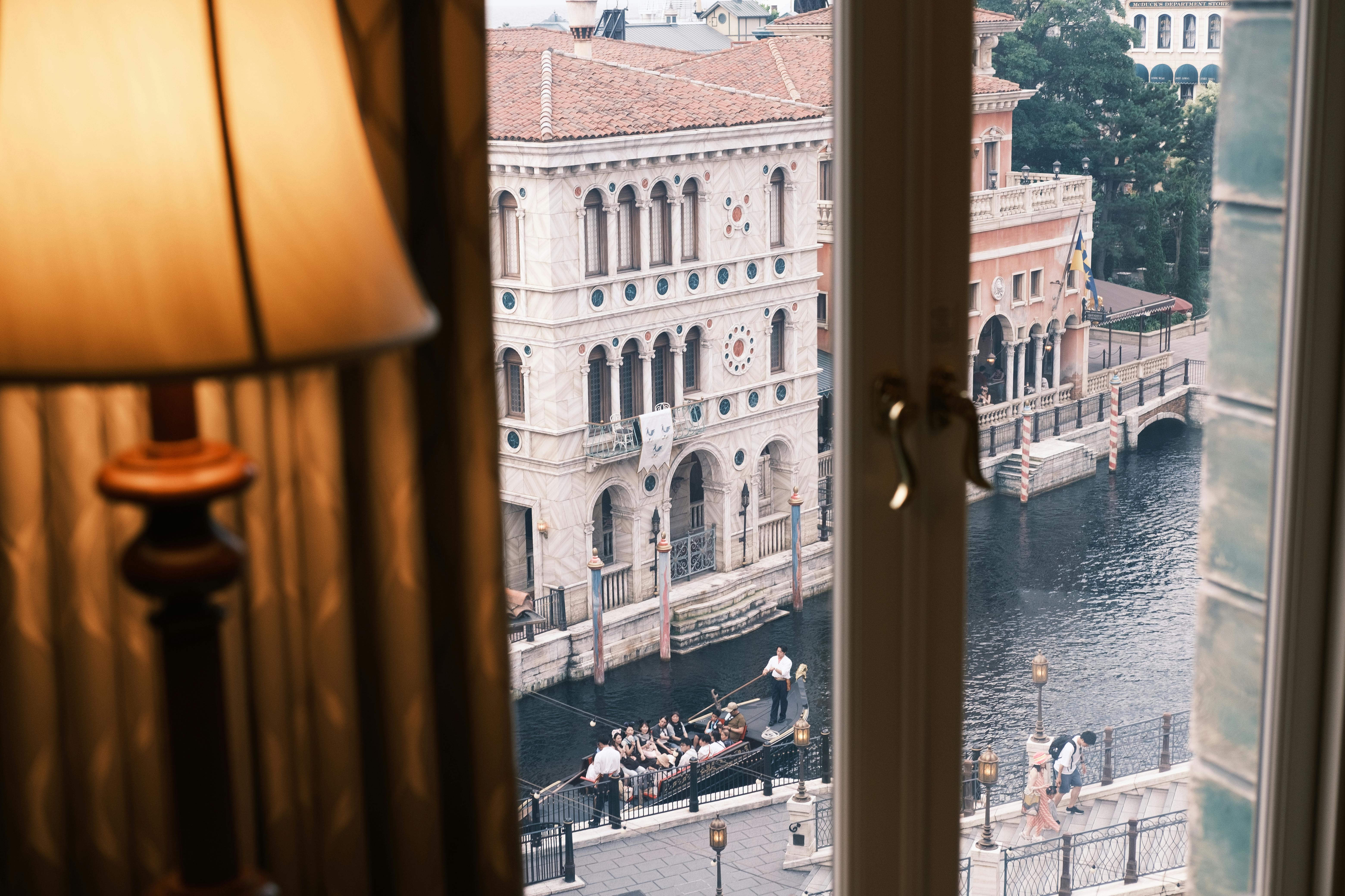 Scenic view of Venetian architecture with a gondola on the canal, seen from indoor window.