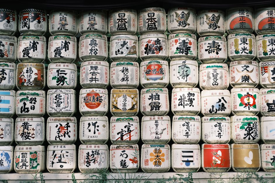 Japanese sake barrels stacked in a wall at a shrine, rich in cultural symbolism.