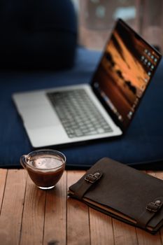A cozy workspace setup with a laptop and coffee cup on a wooden table in İstanbul, Türkiye.