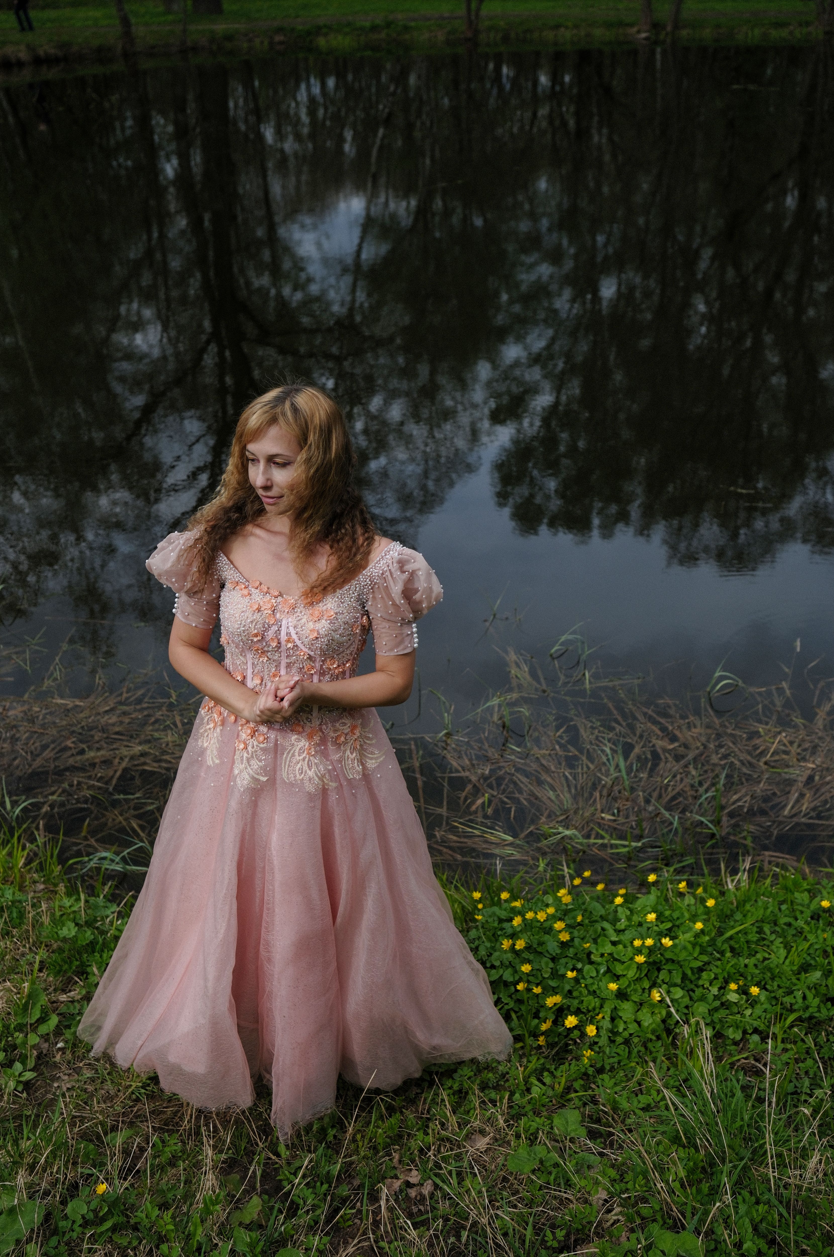 A woman in a pink dress standing by a pond · Free Stock Photo