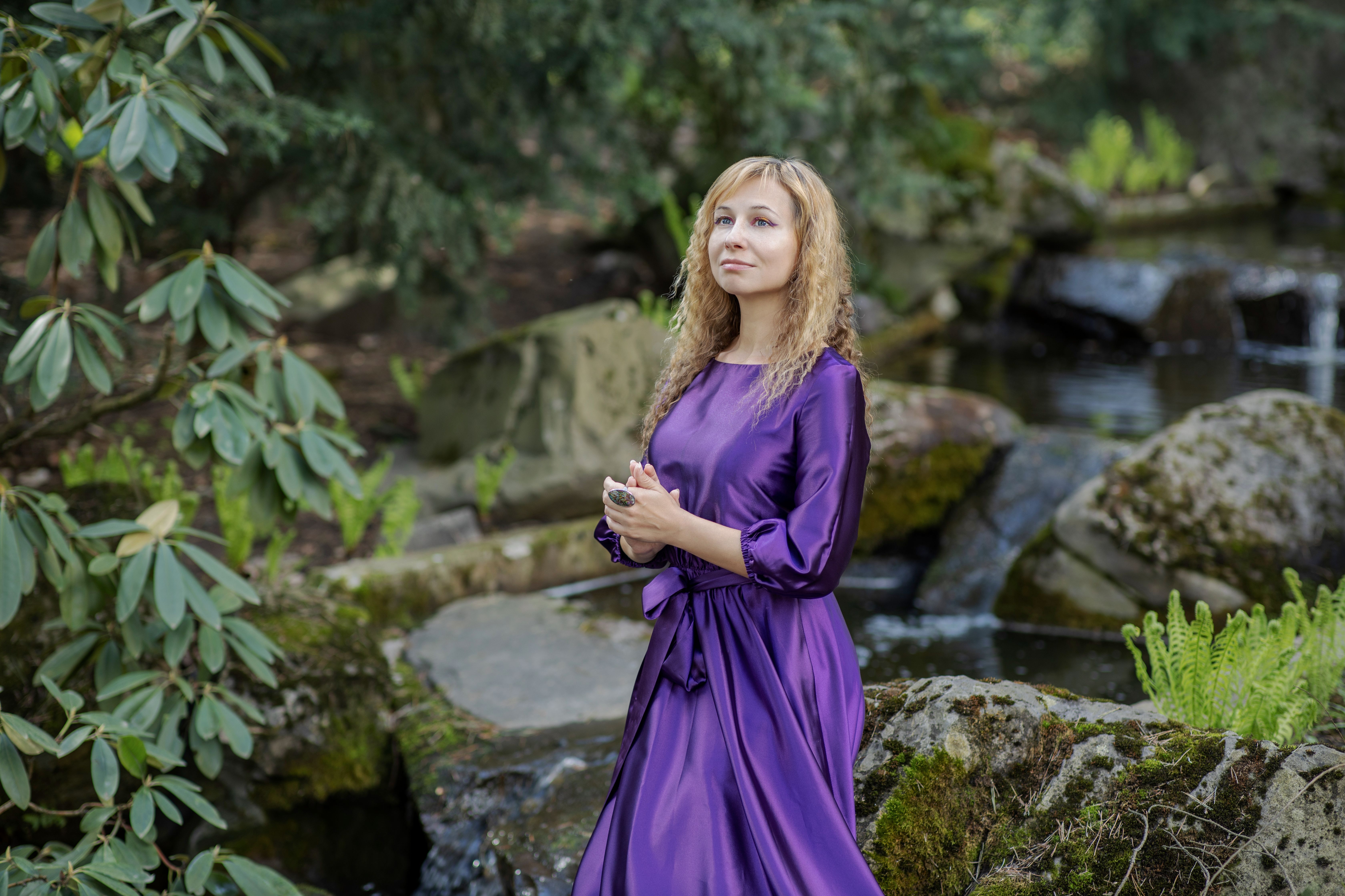A woman in a purple dress standing by a stream · Free Stock Photo