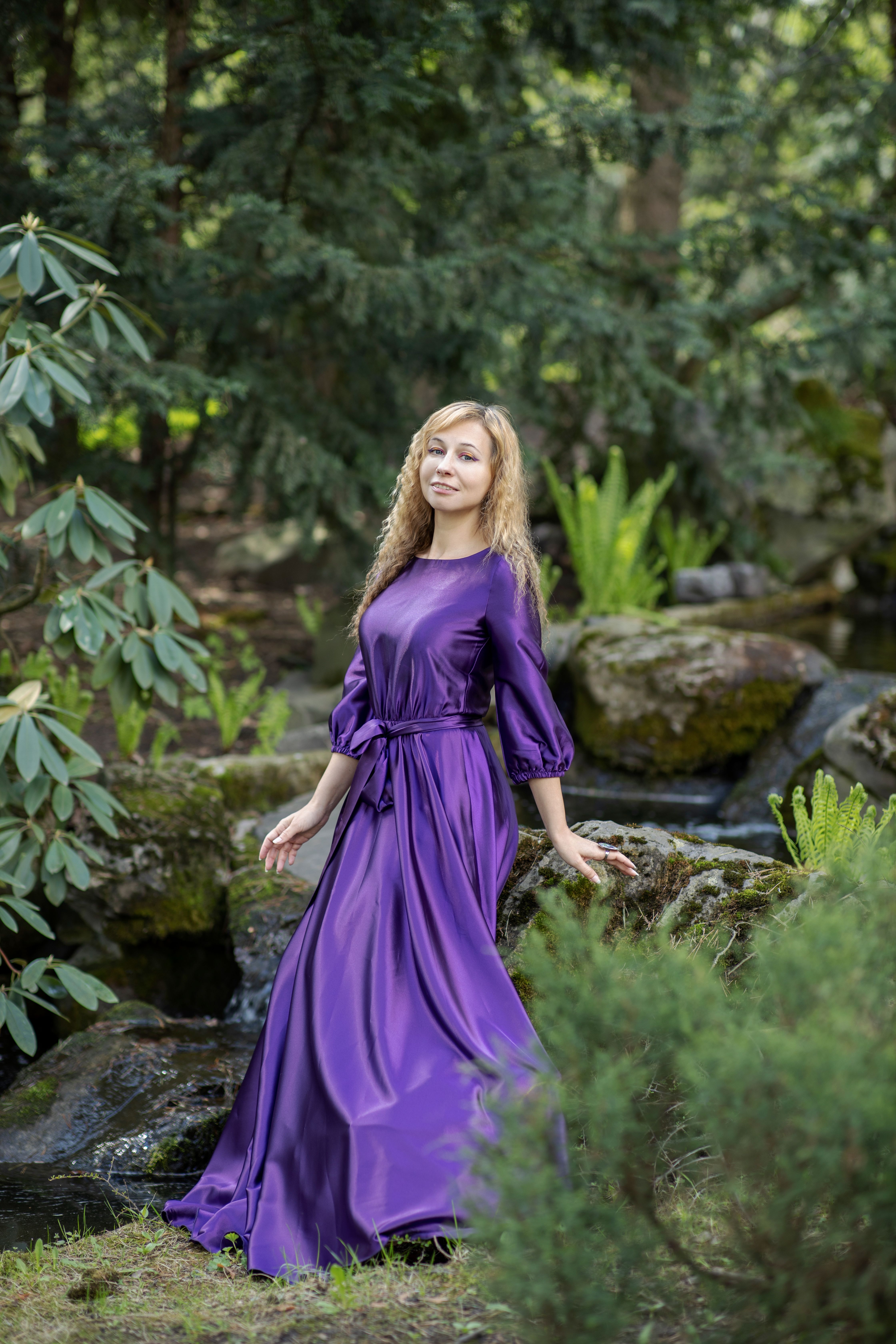 A beautiful woman in a purple dress posing in the woods · Free Stock Photo