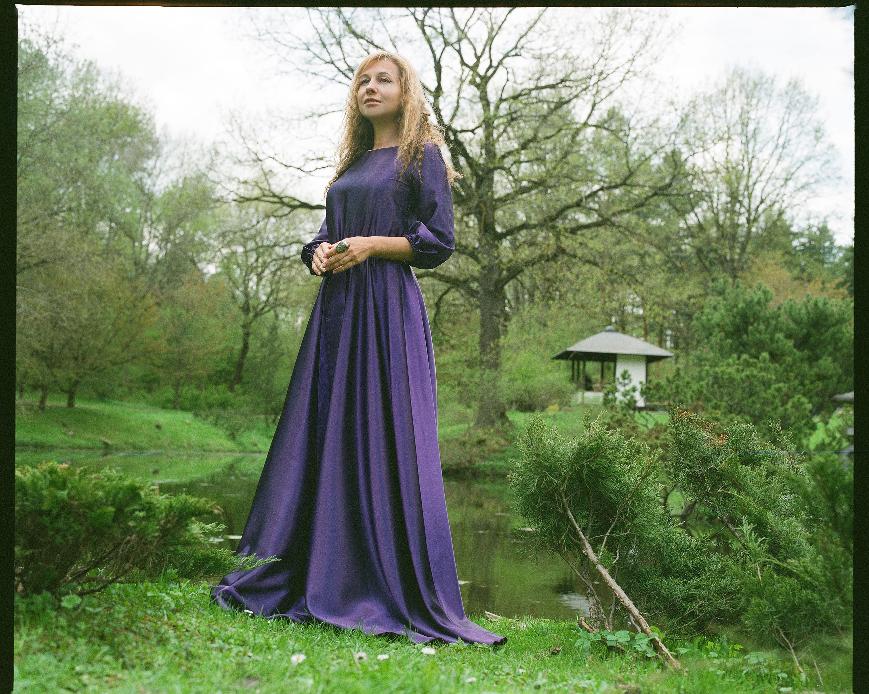 A woman in a purple dress standing in a pond · Free Stock Photo