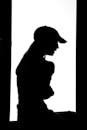 A silhouette of a woman in a baseball cap