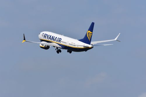 Free A Ryanair aircraft soaring through a clear blue sky, capturing the essence of modern air travel. Stock Photo
