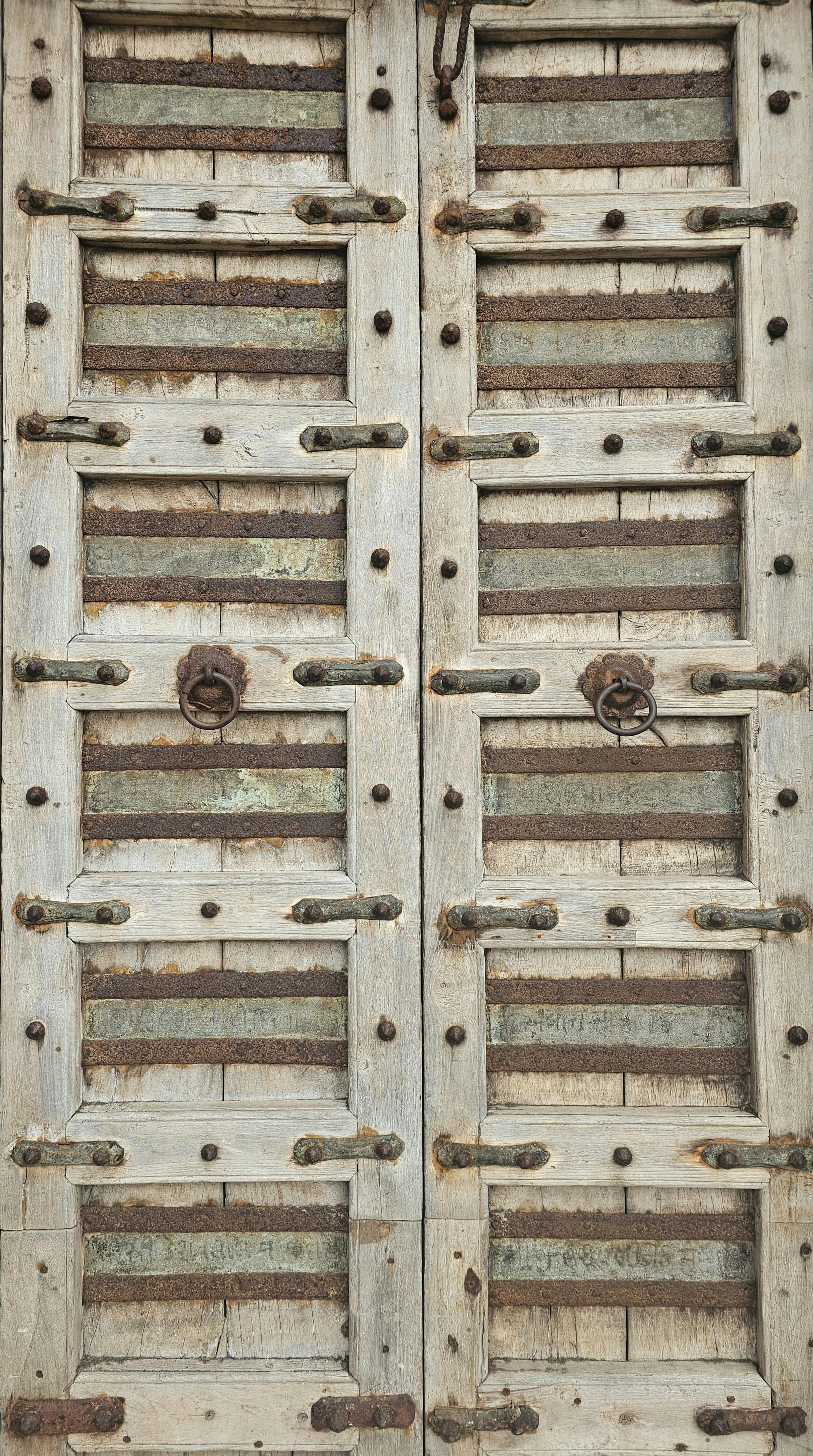 A vintage wooden door with metal details showcasing a rustic, aged texture.