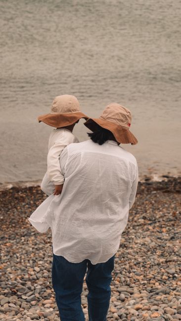 A peaceful moment shared by a parent and child on a rocky beach.