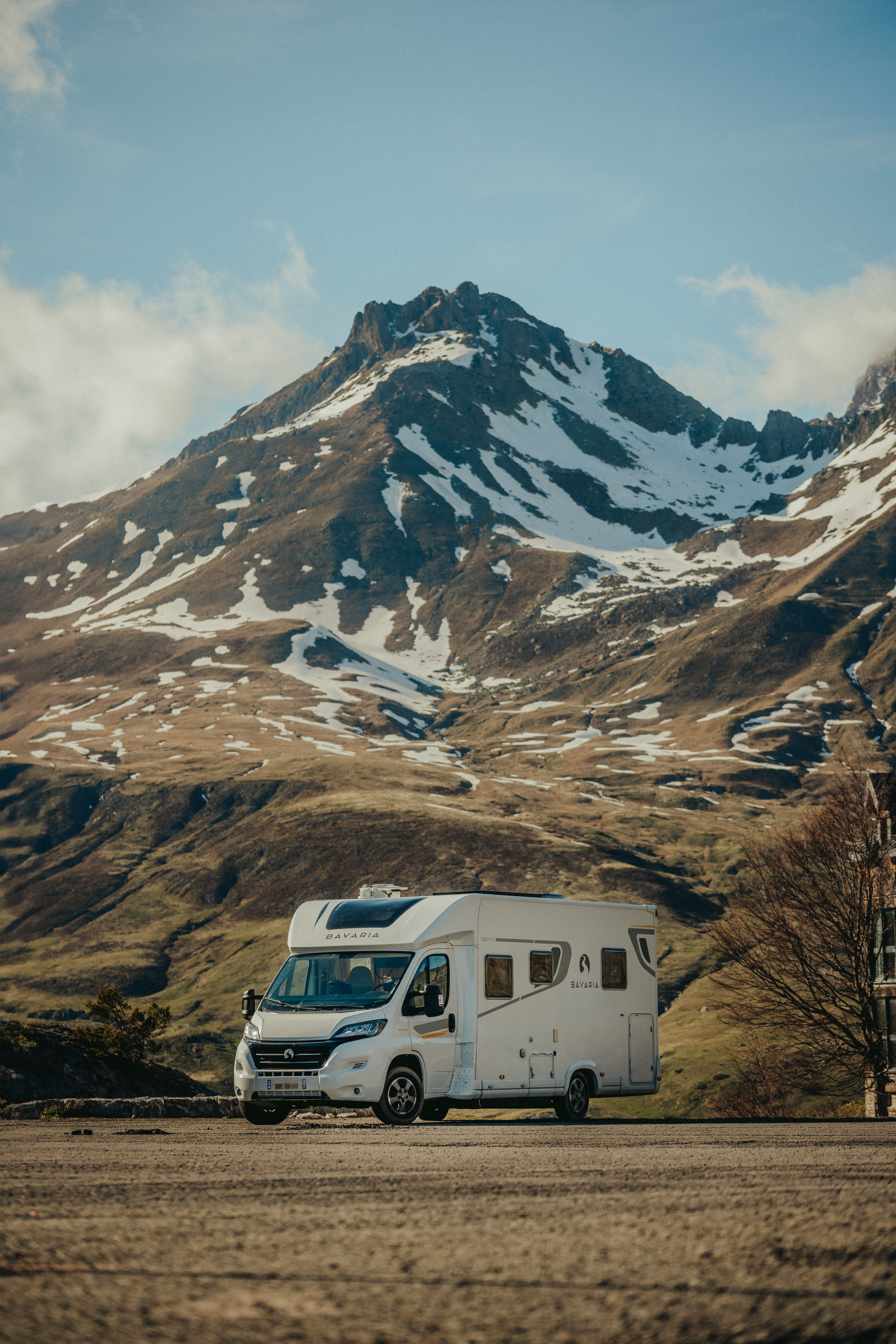 Motorhome grande estacionado diante de uma cordilheira nevada nos Alpes