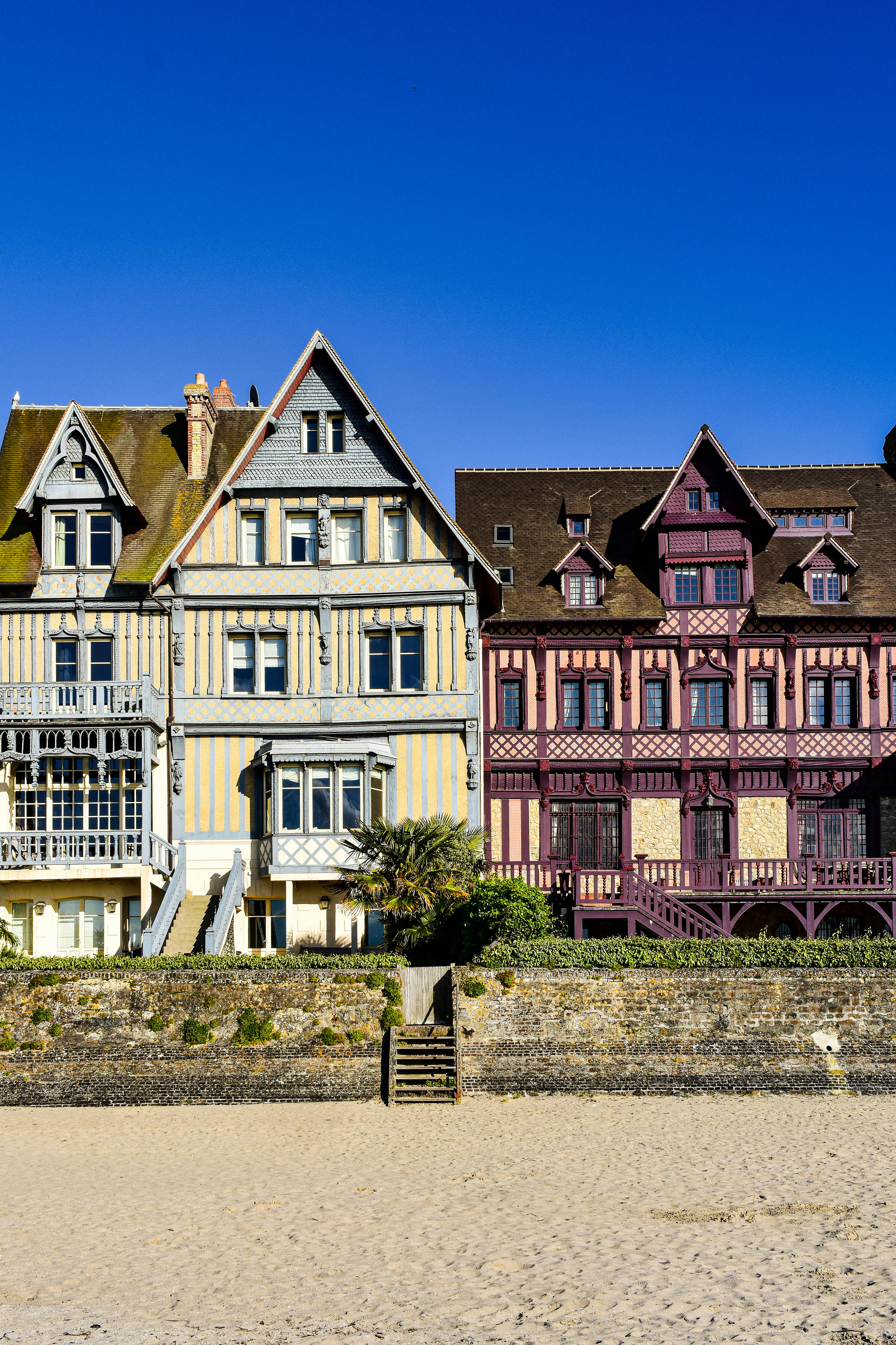 a row of houses on the beach with a blue sky