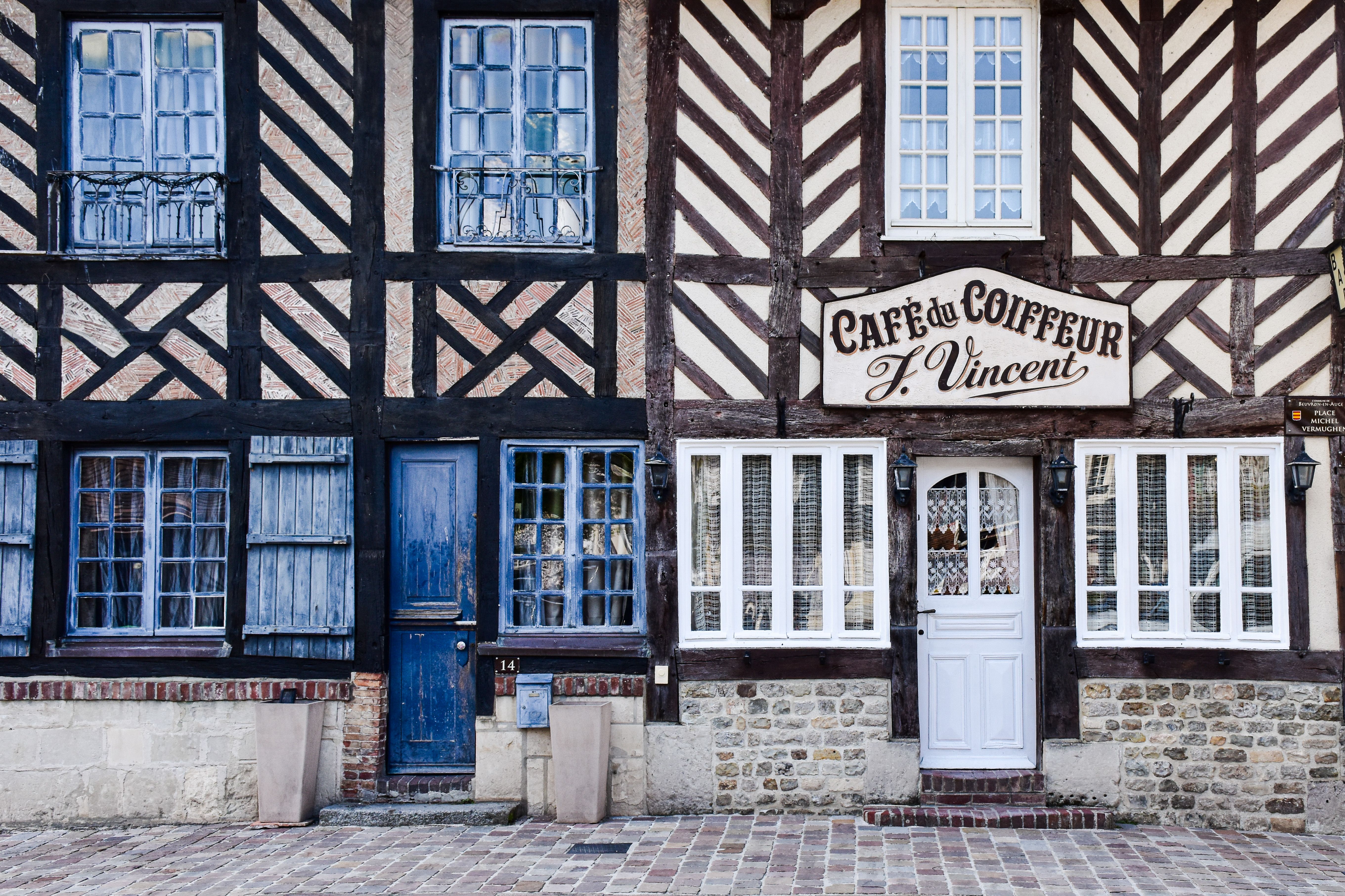 Discover the vintage facade of a Normandy café with classic half-timbered design.