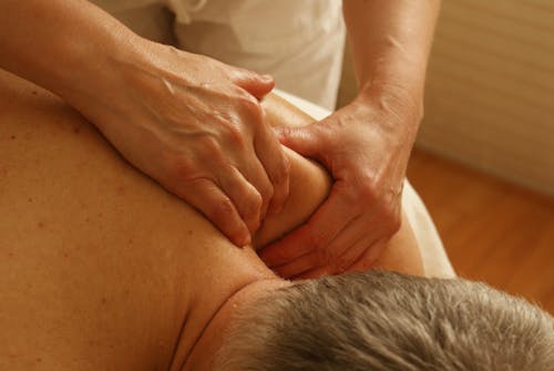 Free Person Massaging Man's Shoulder Stock Photo