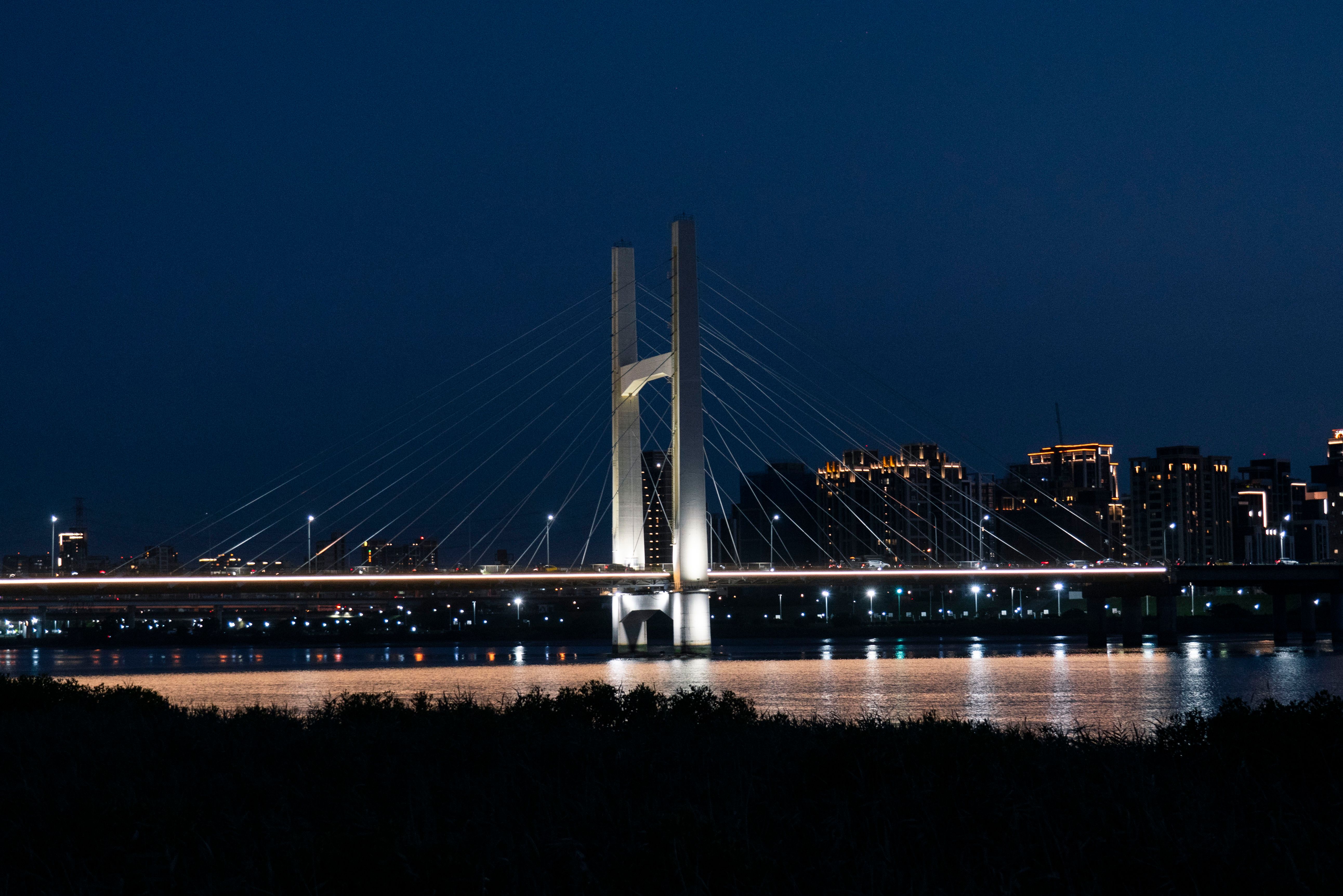 A bridge over water at night with lights · Free Stock Photo