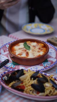 Delicious Italian lasagna with bubbling cheese served with a side of seafood pasta.