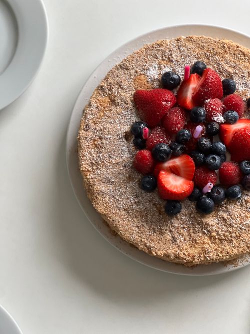 Free Mouthwatering cake garnished with fresh strawberries and blueberries, perfect for breakfast or dessert. Stock Photo