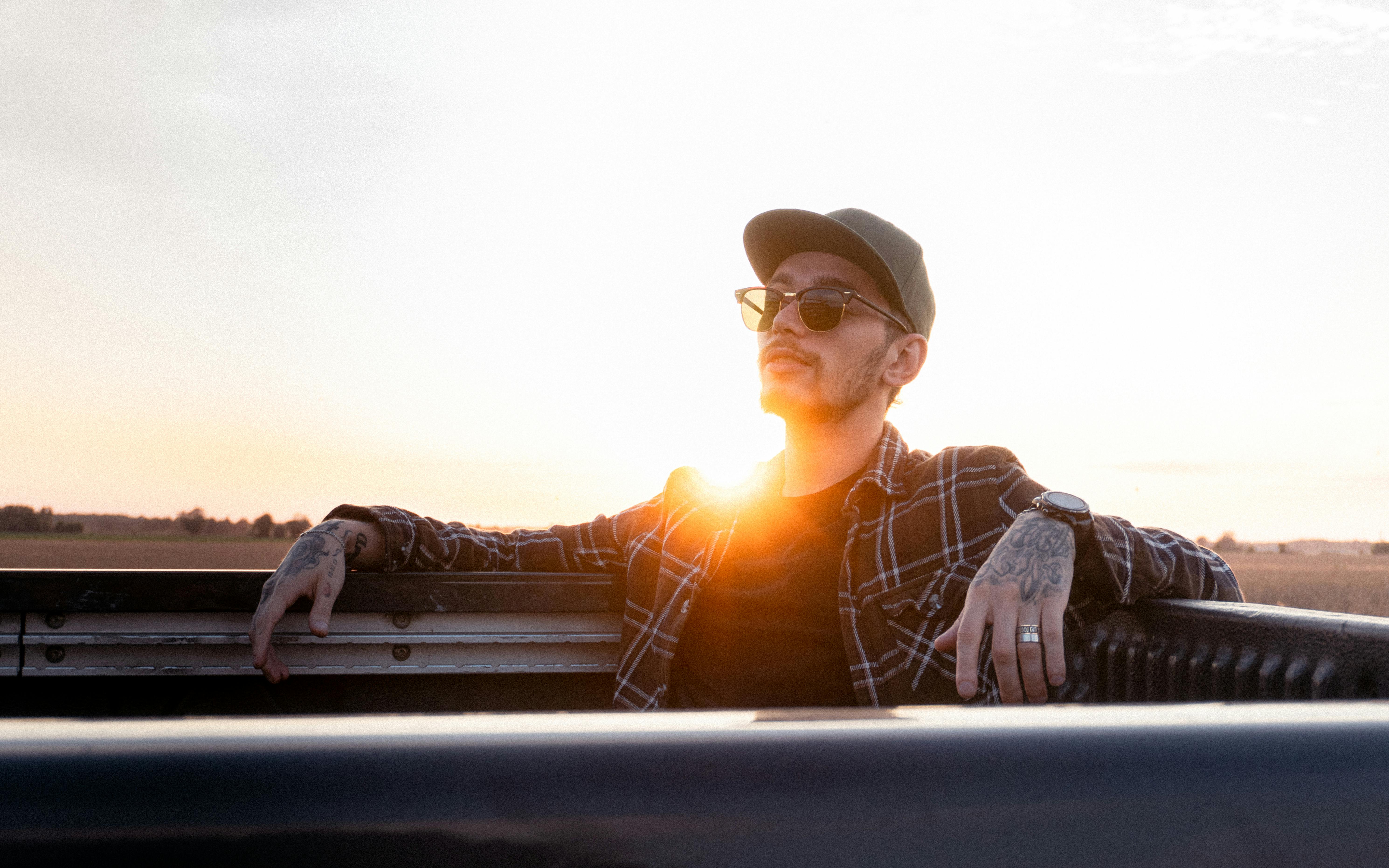 a man in sunglasses sitting in the back of a truck