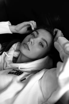 Stylish black and white portrait capturing an elegant woman in a relaxed pose.