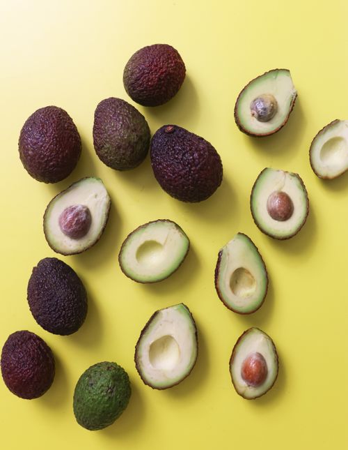 Free A vibrant display of whole and sliced avocados against a bright yellow backdrop depicting health and freshness. Stock Photo