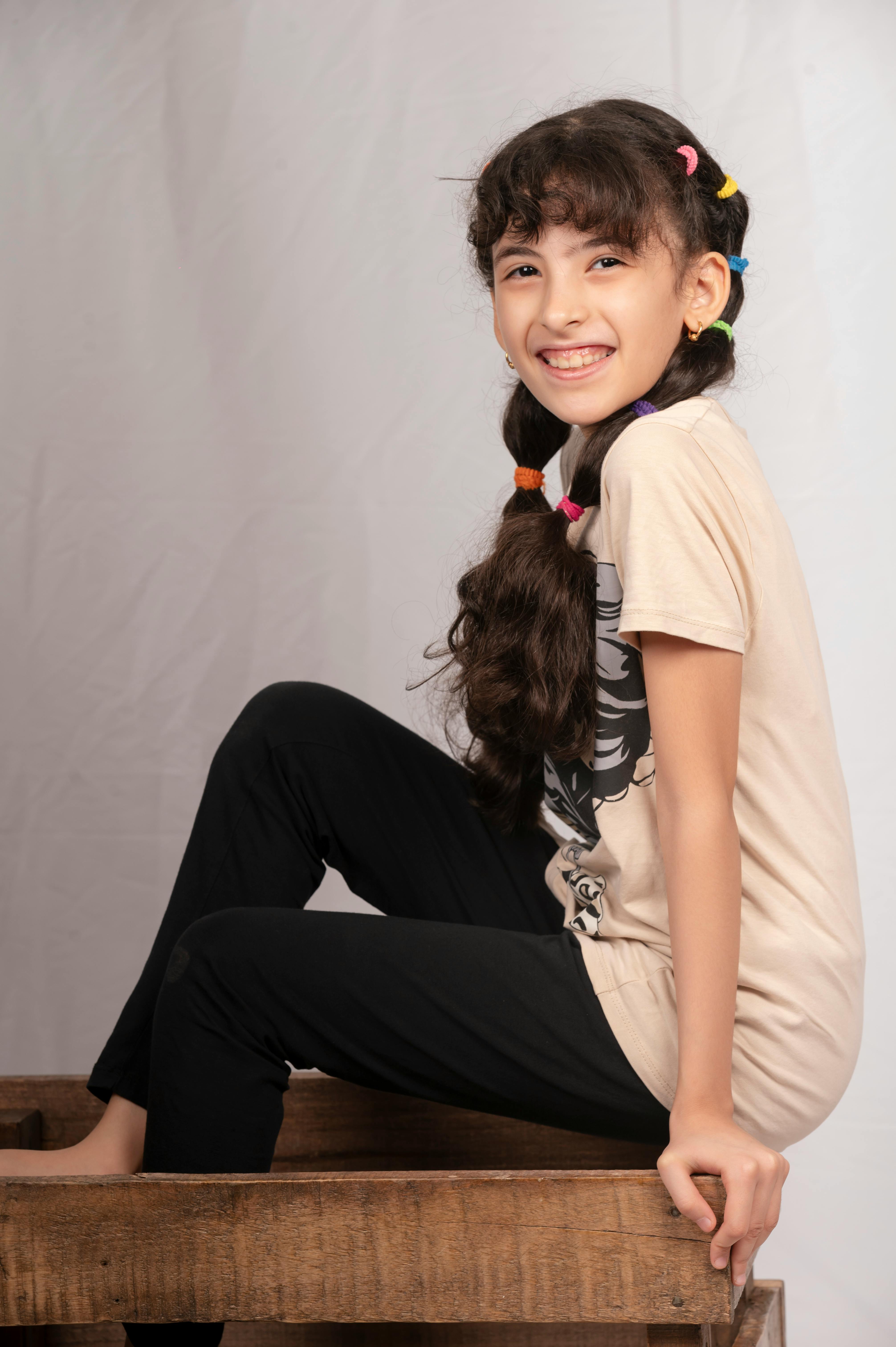 a young girl sitting on a wooden box