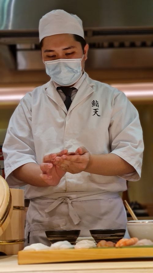 Free A sushi chef skillfully prepares food in a Japanese restaurant, showcasing culinary expertise. Stock Photo