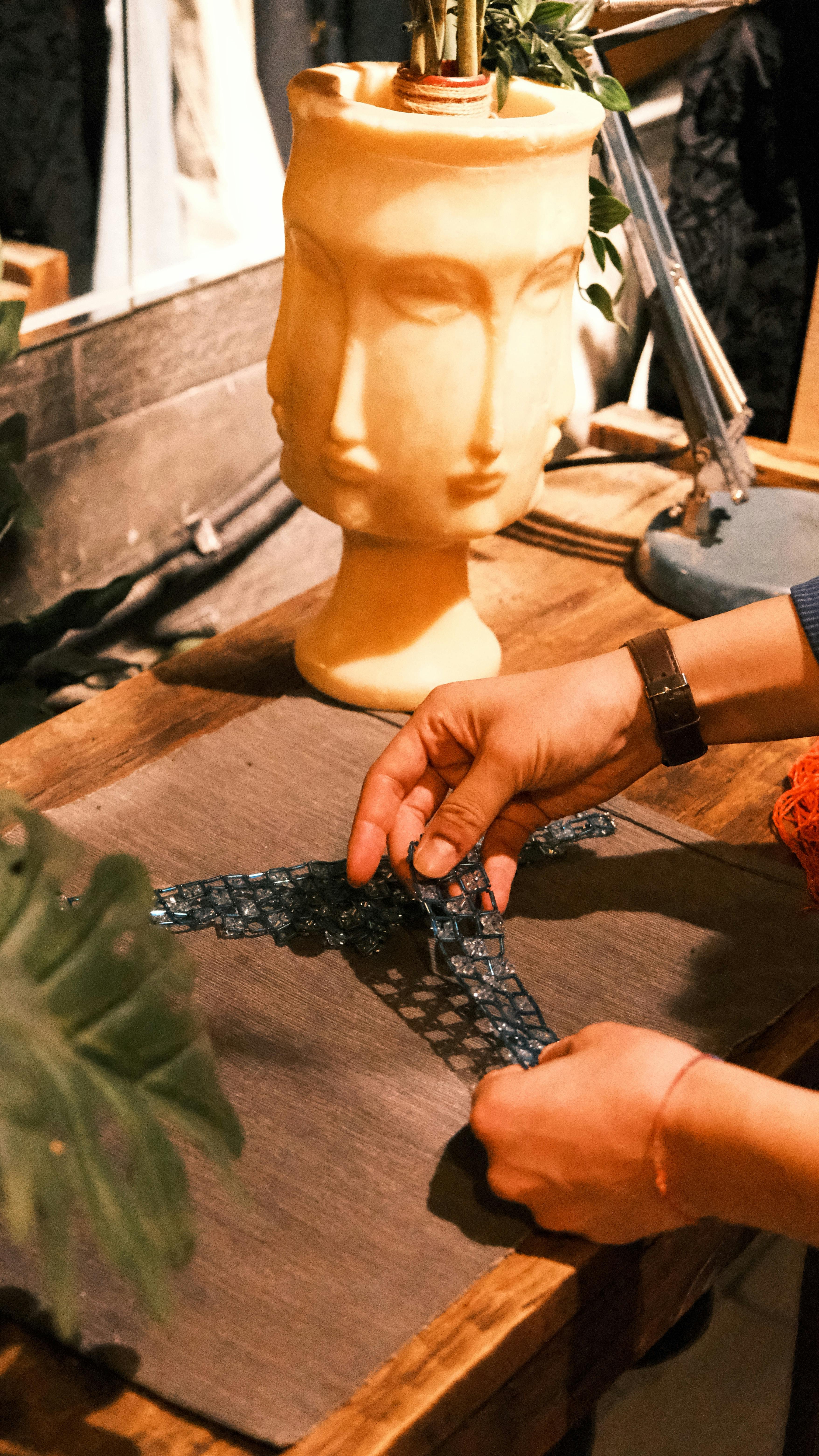 a person is making a necklace with a vase