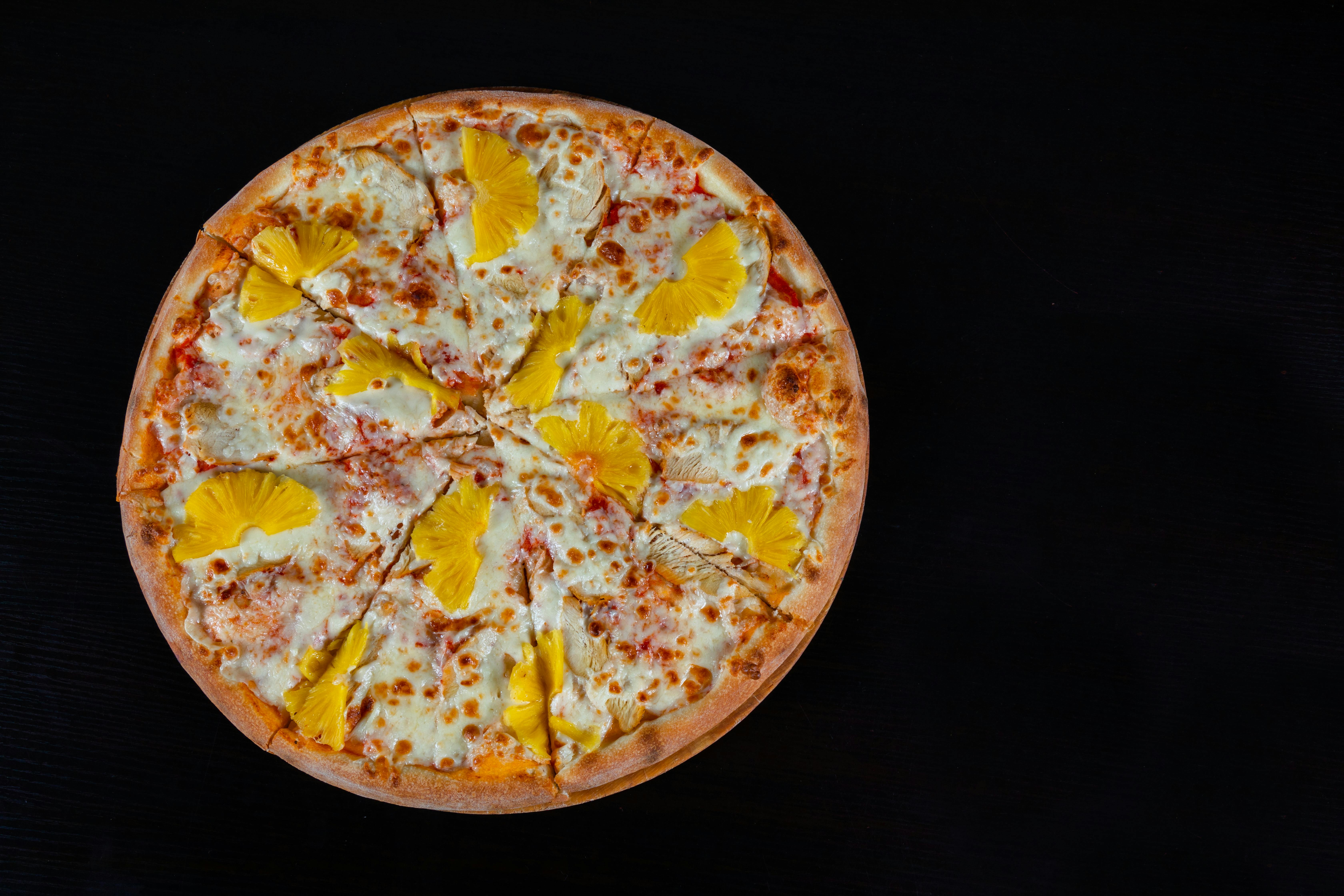 A mouthwatering Hawaiian pizza topped with cheese and pineapple.