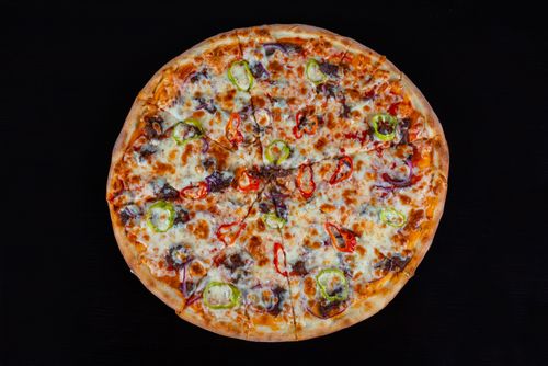 Free Tasty pepperoni pizza with cheese and vegetables on a dark background. Stock Photo