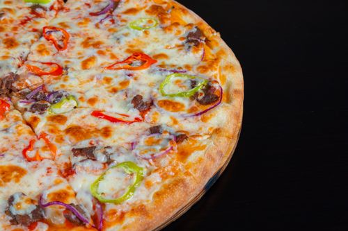 Free Delicious pizza topped with pepperoni, bell peppers, and cheese, ready to eat. Stock Photo