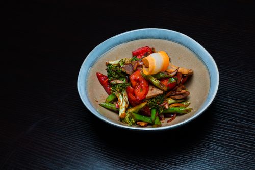 Free Colorful vegetable stir fry with broccoli, peppers, and carrots in a ceramic bowl on a dark table. Stock Photo