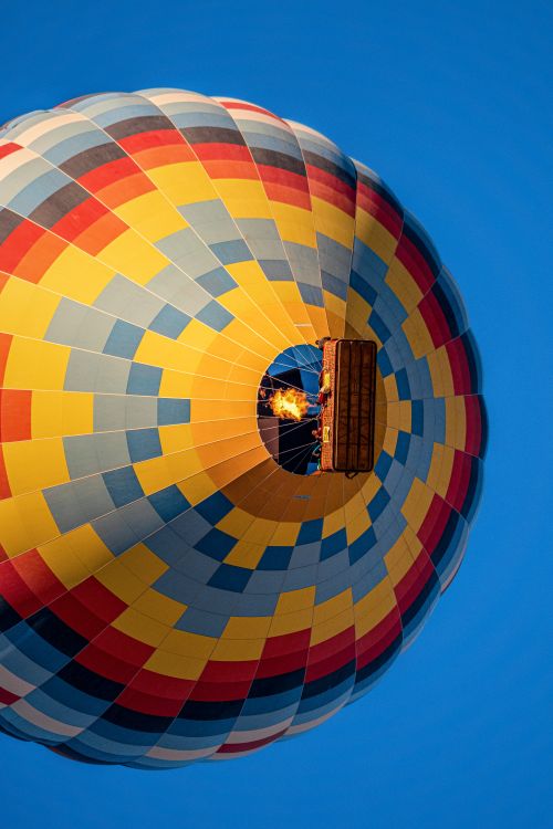 Free A vibrant hot air balloon ascending through the clear blue sky in Nevşehir, Türkiye. Stock Photo