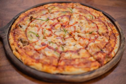 Free Tasty pepperoni and cheese pizza on a rustic wooden tray, ideal for dinner or sharing. Stock Photo