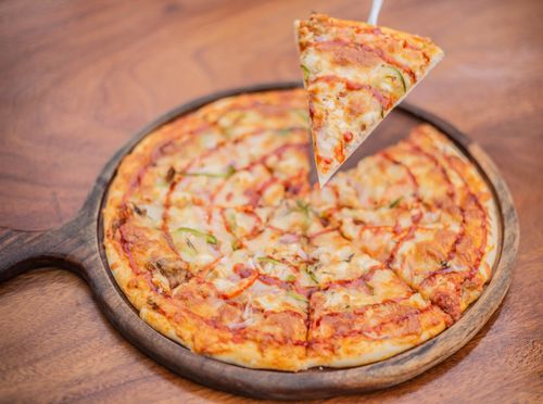 Free Sliced pepperoni pizza with melted cheese on wooden board, perfect for lunch or dinner. Stock Photo