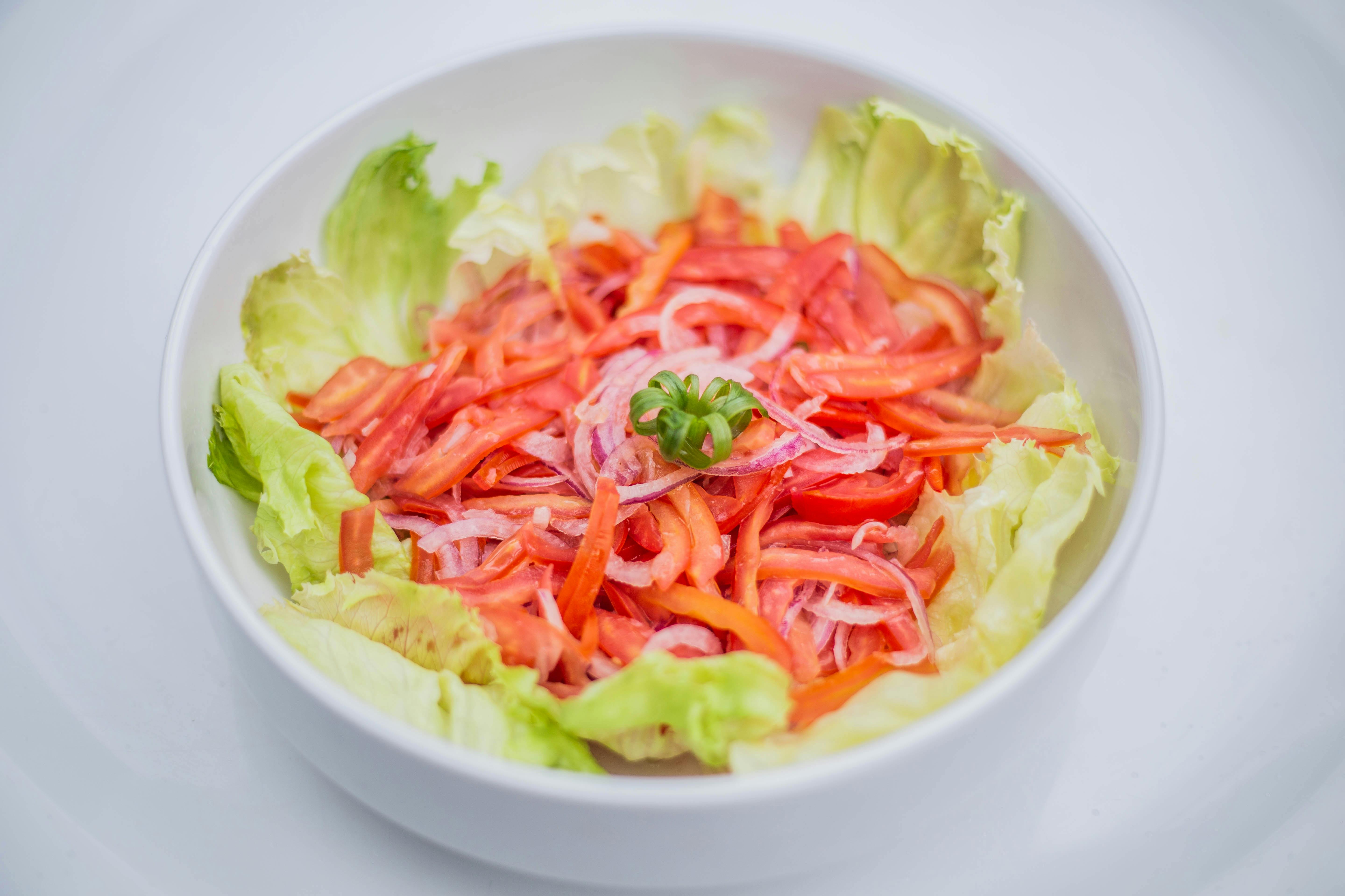 a bowl of salad with tomatoes and onions