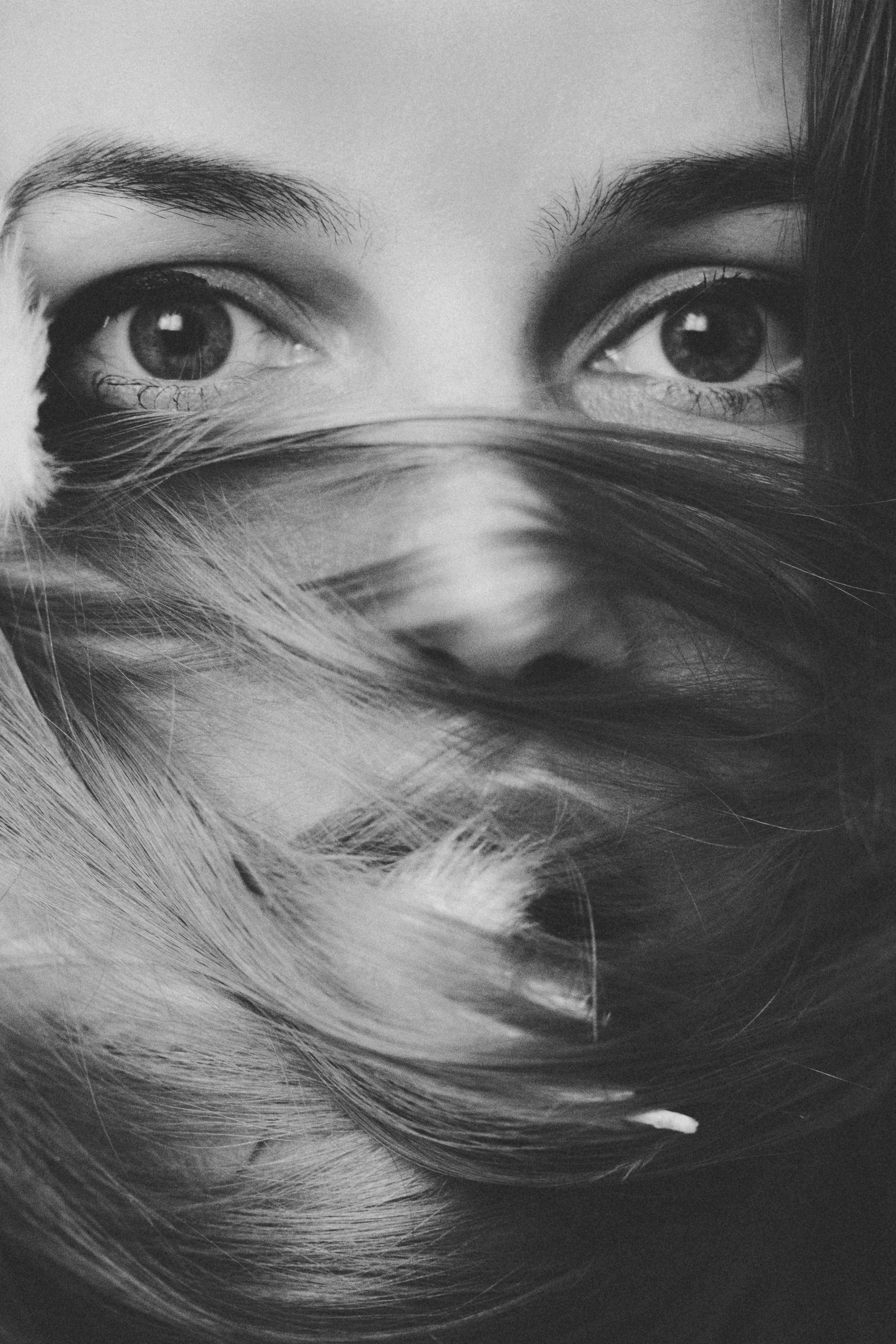 Striking black and white portrait focusing on the eyes and hair of a mysterious woman.