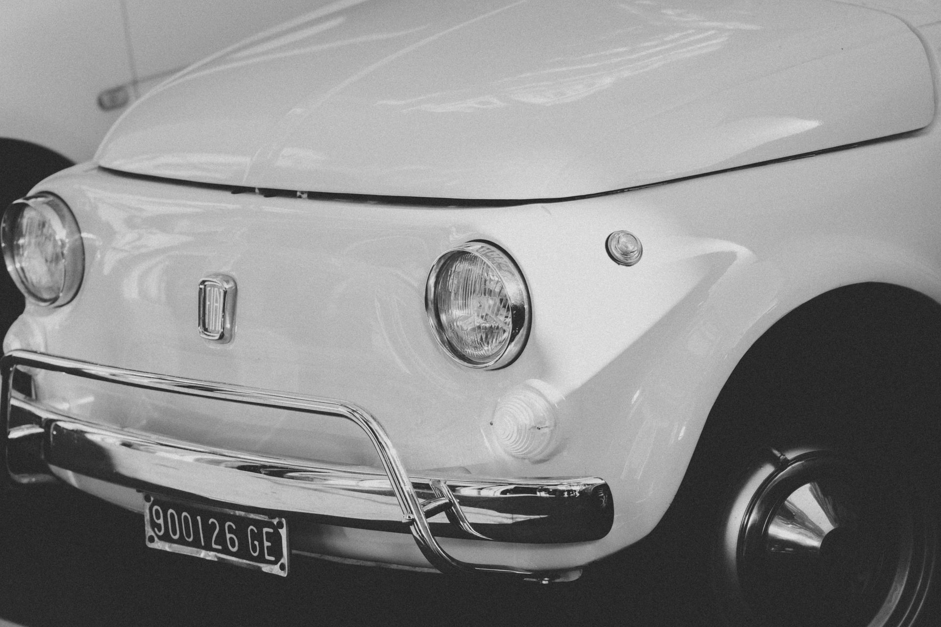 Black and white photo of a white fiat car