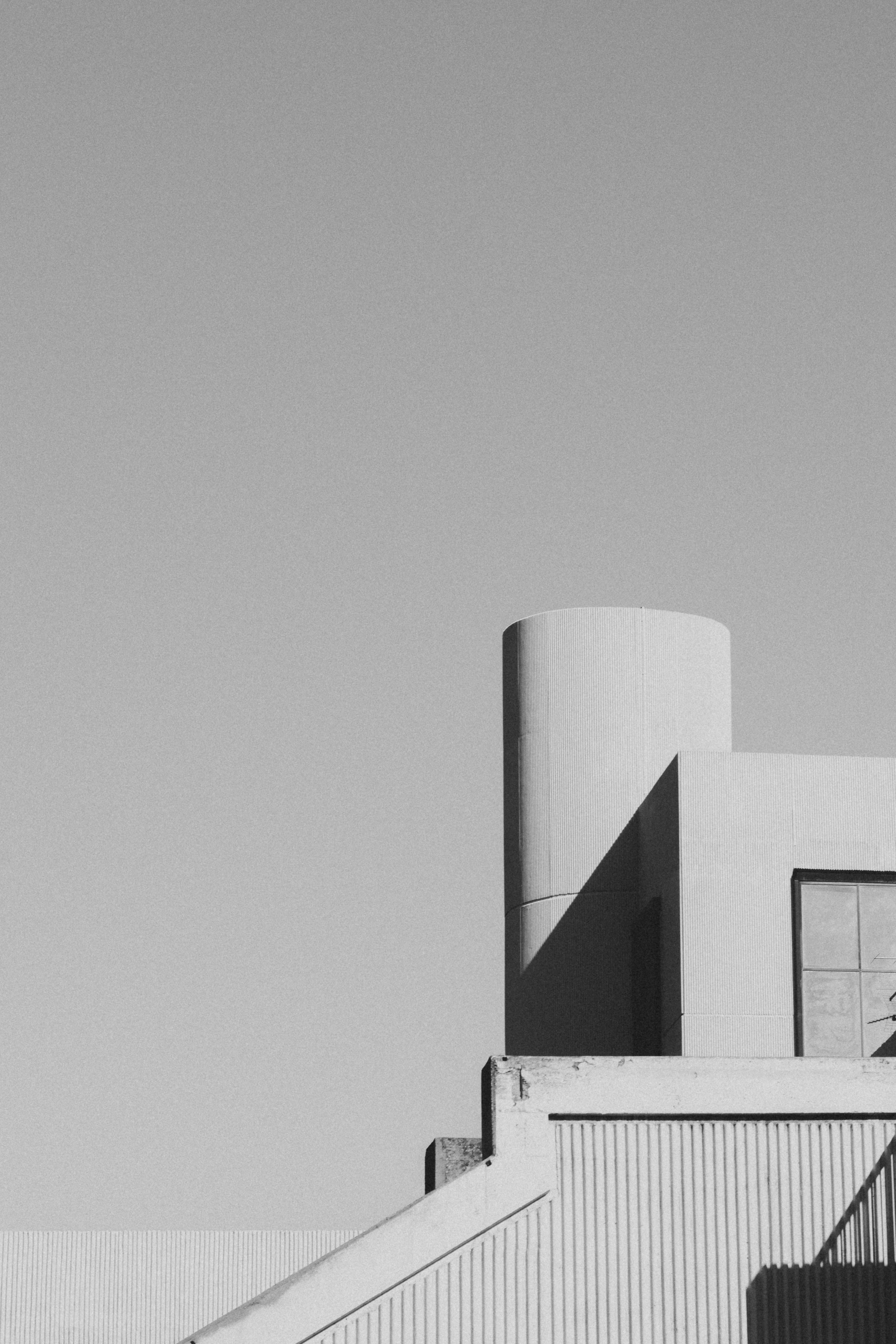 Black and white image of a minimal modern industrial building with geometric shapes.