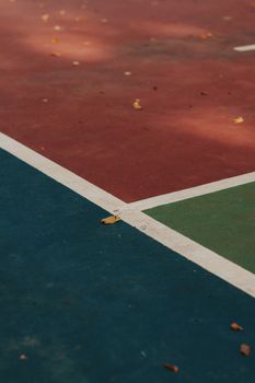 Close-up of a vibrant outdoor basketball court showing intersecting painted lines.