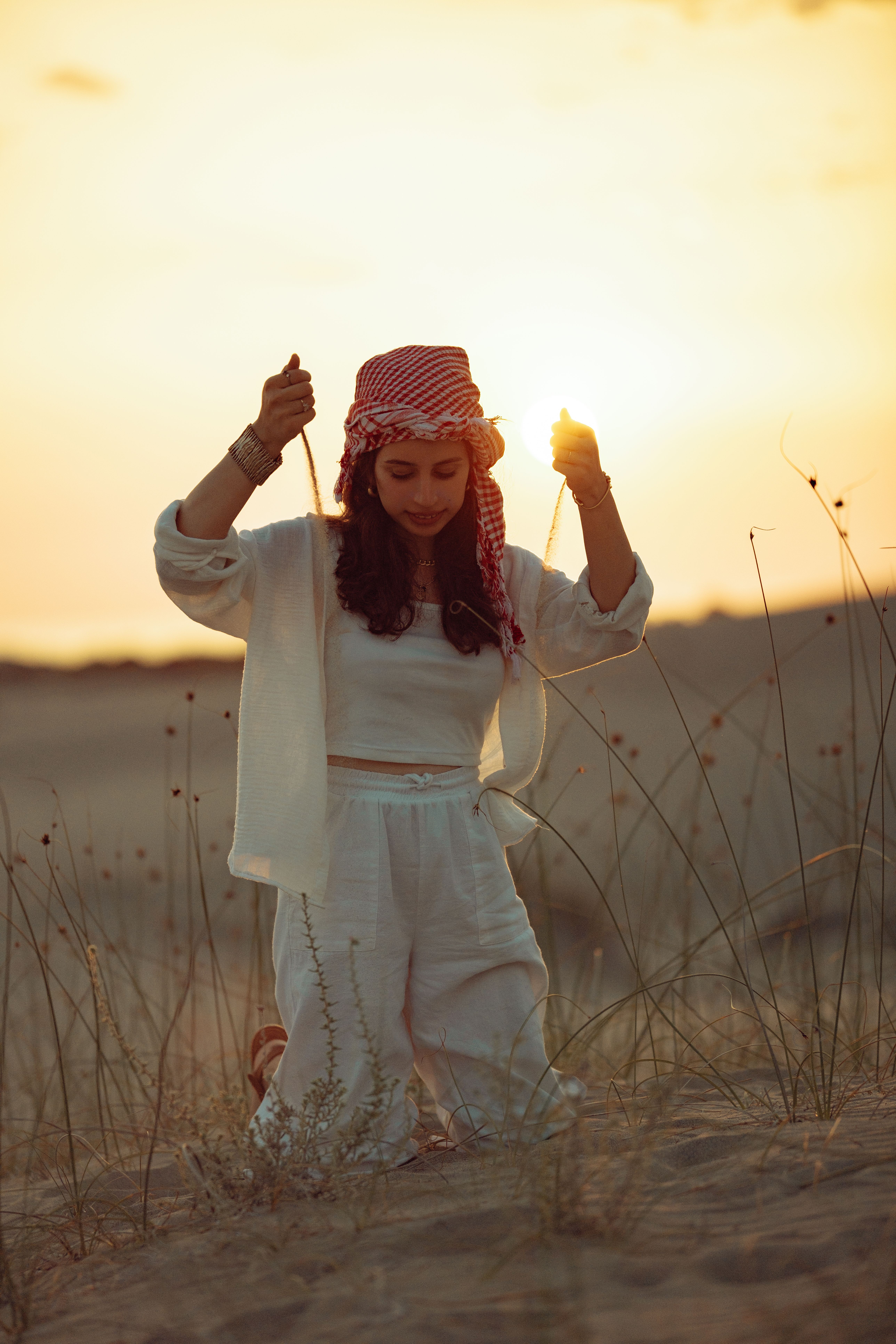A woman in a white outfit is standing in the desert · Free Stock Photo