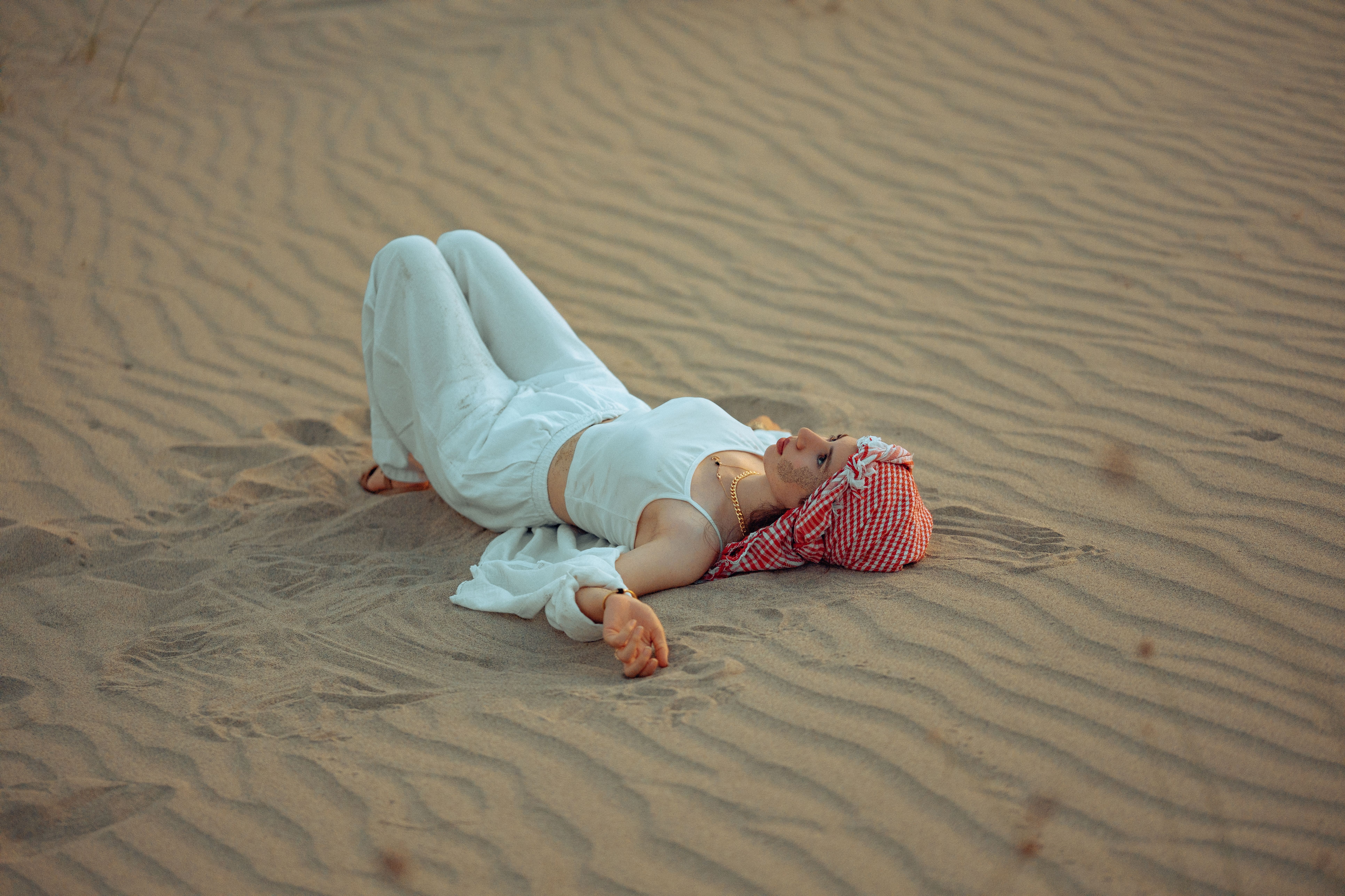 A woman laying on the sand in the desert · Free Stock Photo