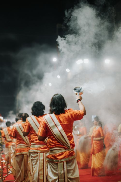 Free Back view of traditional ceremony with incense, dancers, and smoke under night lights. Stock Photo