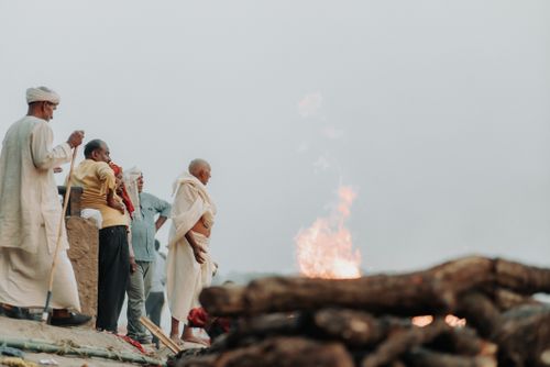 Free Men gathered for a traditional ceremony by the riverside with a fire. Stock Photo