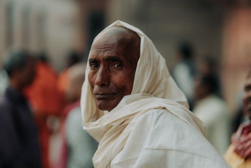 Free Elderly man in traditional attire, captured in a contemplative moment. Street scene. Stock Photo