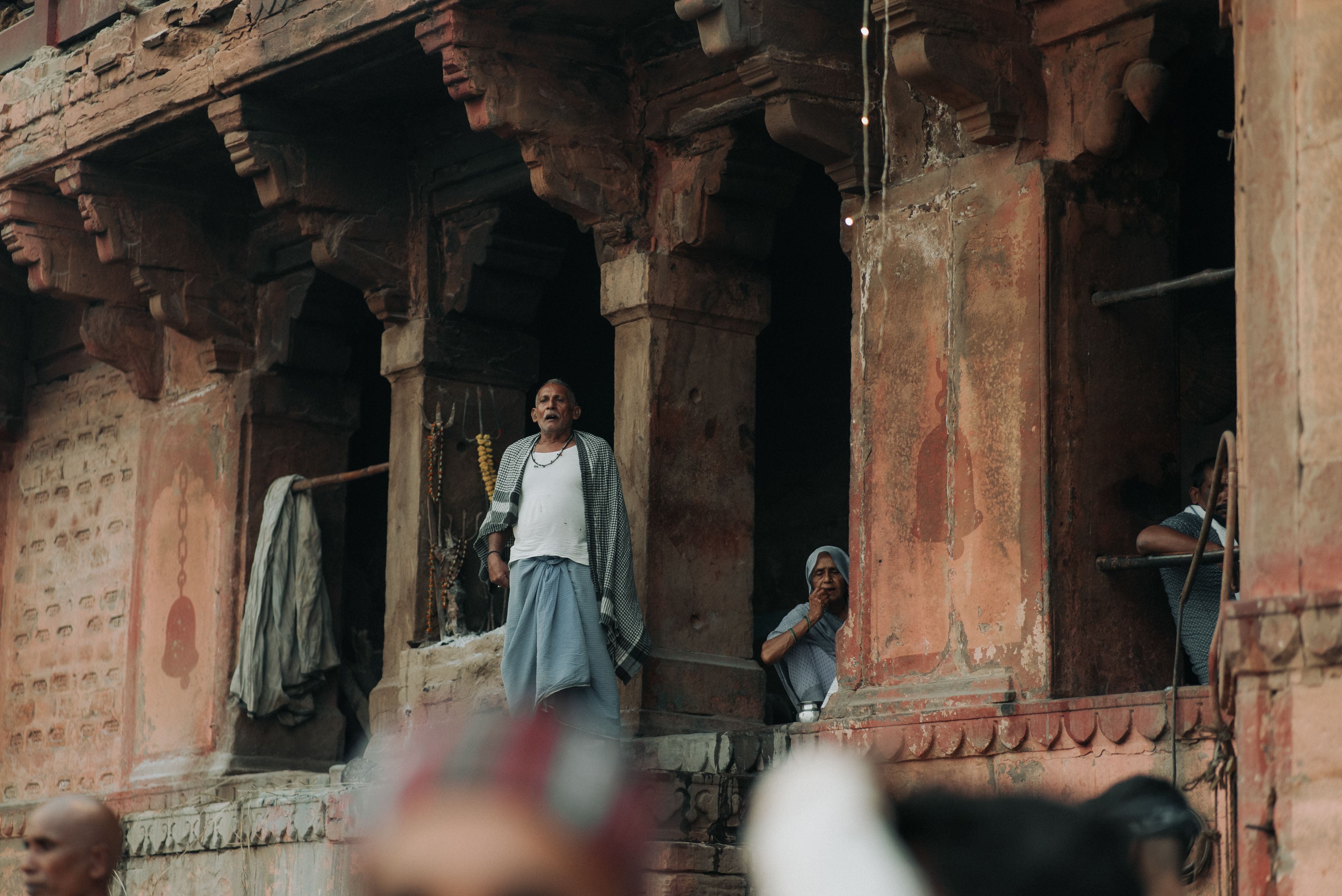 Men standing in the arched windows of an ancient temple, highlighting cultural architecture.