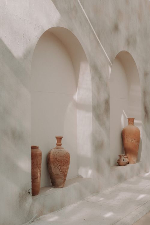 Free Three terracotta pots in a sunlit niche of an ancient stone building Stock Photo
