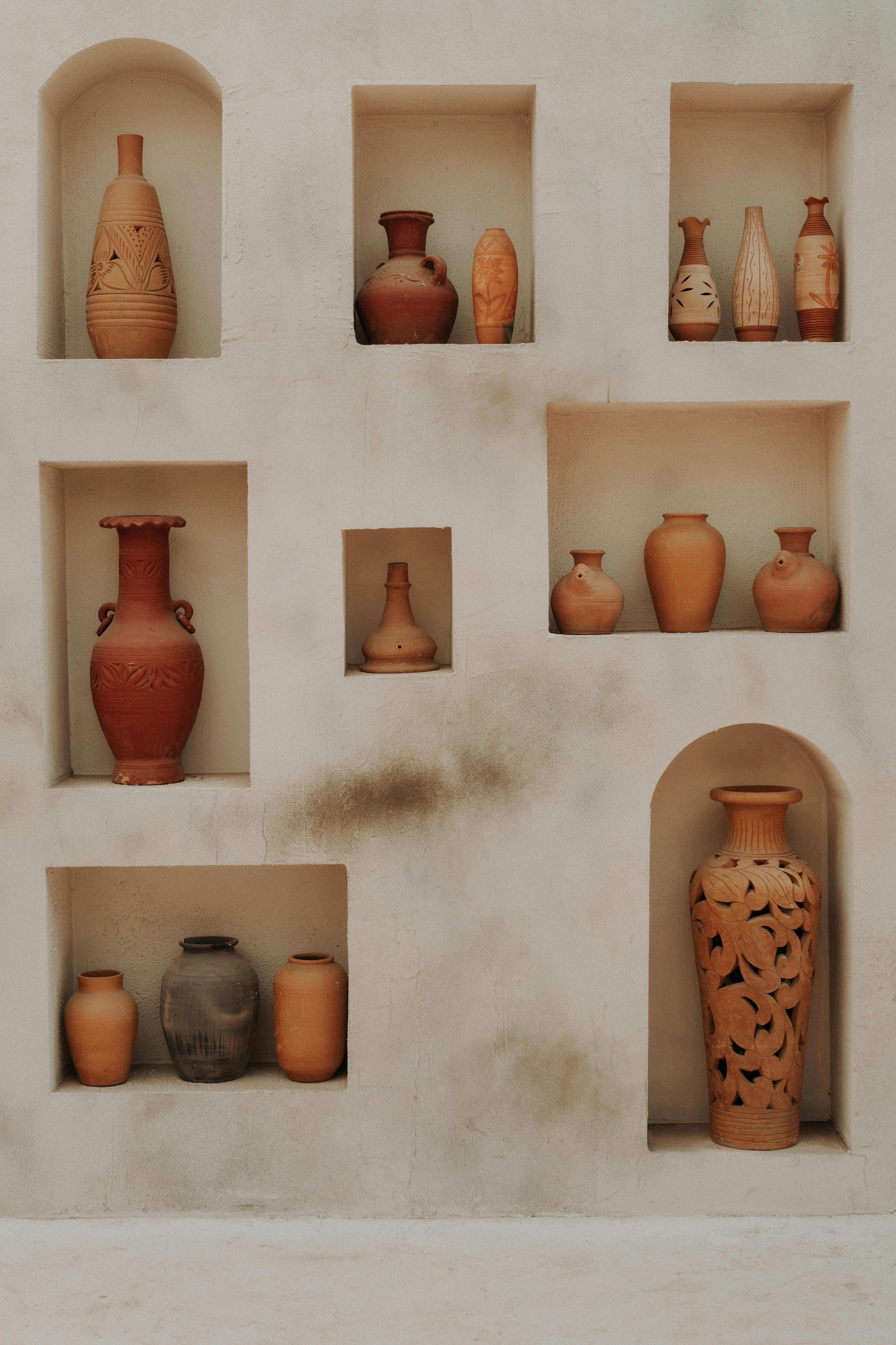 Aesthetic arrangement of traditional clay pottery in a rustic wall setting, showcasing artistic craftsmanship.