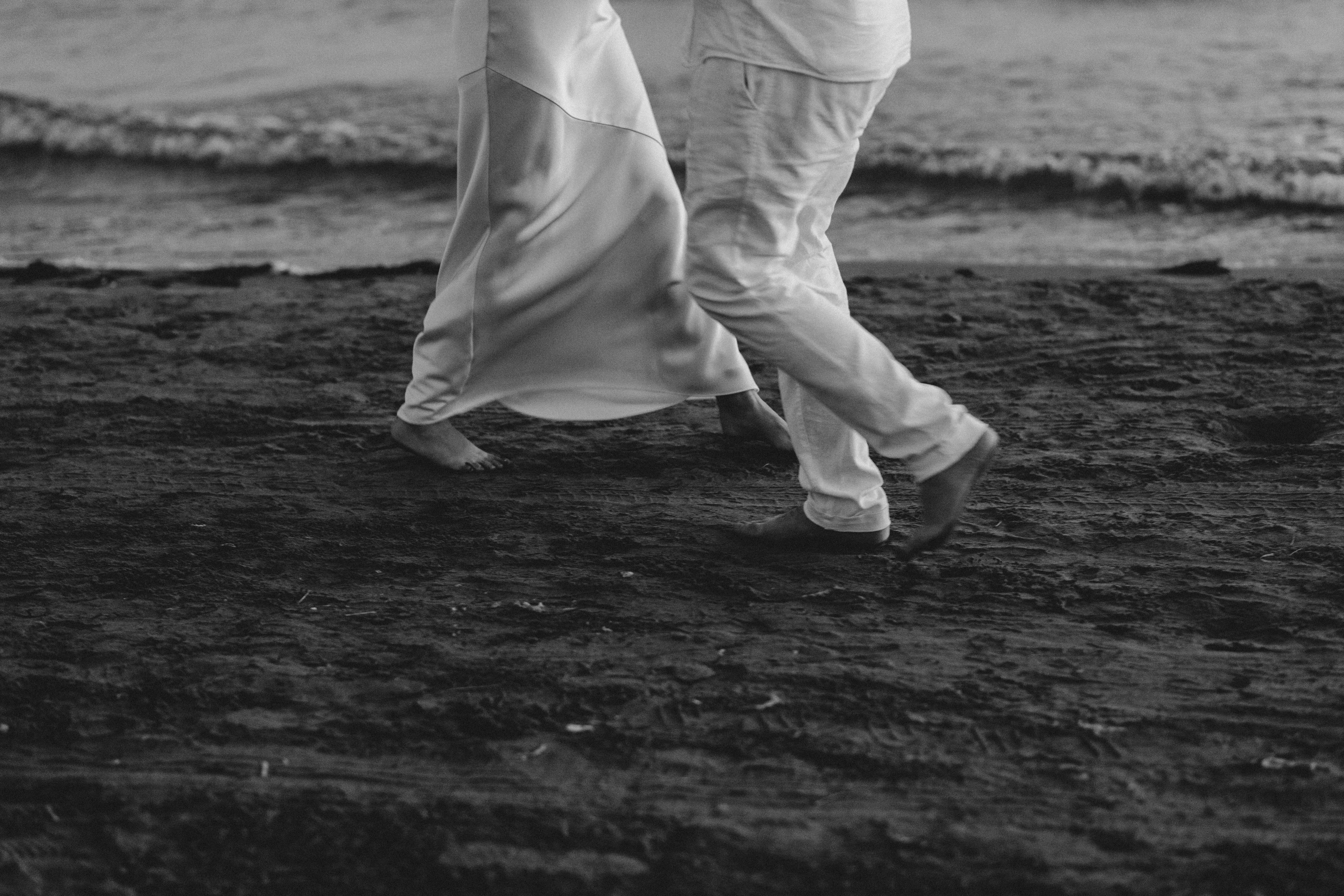 A black and white photo of a couple walking on the beach · Free Stock Photo