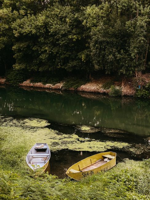 Peaceful riverside with two boats and lush greenery, ideal for nature and travel themes.
