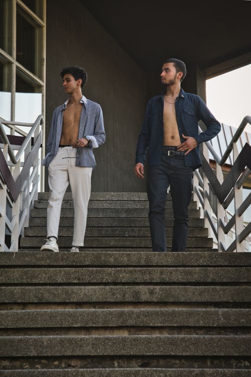 Free Two fashionable young men descend modern stairs in an urban setting, showcasing contemporary style in Berlin. Stock Photo