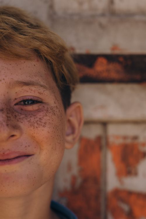 Free Close-up portrait of a smiling freckled child outdoors in Kafr El-Shaikh, Egypt. Stock Photo