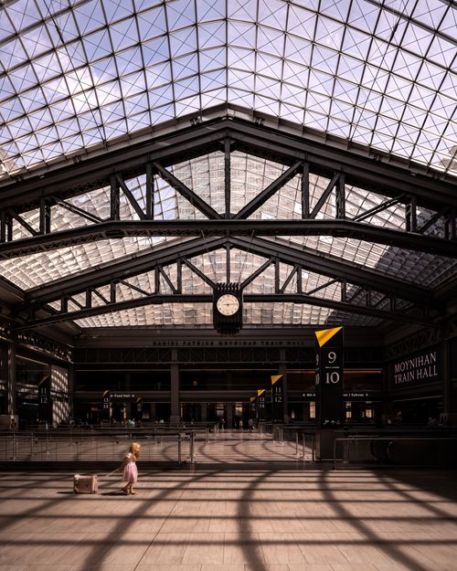 Free Wide-angle view of Moynihan Train Hall with a child and suitcase, showcasing modern architecture. Stock Photo